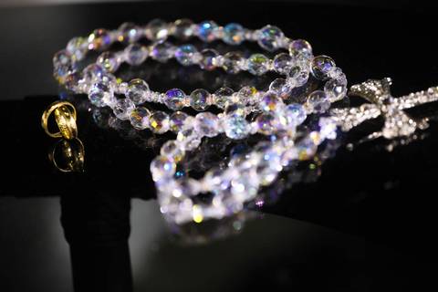 Making of da noiva ao entardecer com vestido e cidade ao fundo no hotel patropi alianças e terço'