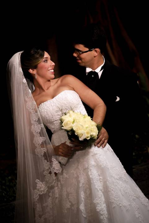 Ensaio do casal, durante o casamento. Foto posada do noivo e noiva com bouquê, vestido e paletó.'
