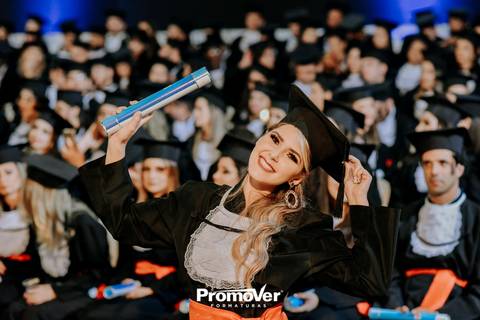 formanda de beca comemorando colação de formaturas'