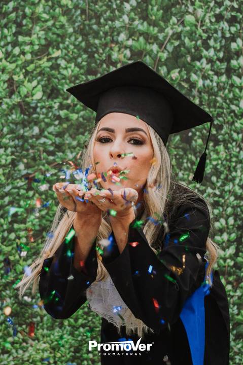 formanda assoprando confete na festa de colação'