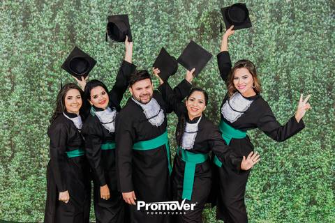 turma de formando com capelo na colação de formaturas'