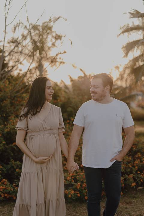 Casal caminhando em ensaio de gestante ao por do sol '