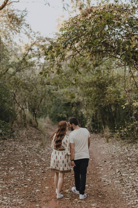 Casal caminhando em floresta'