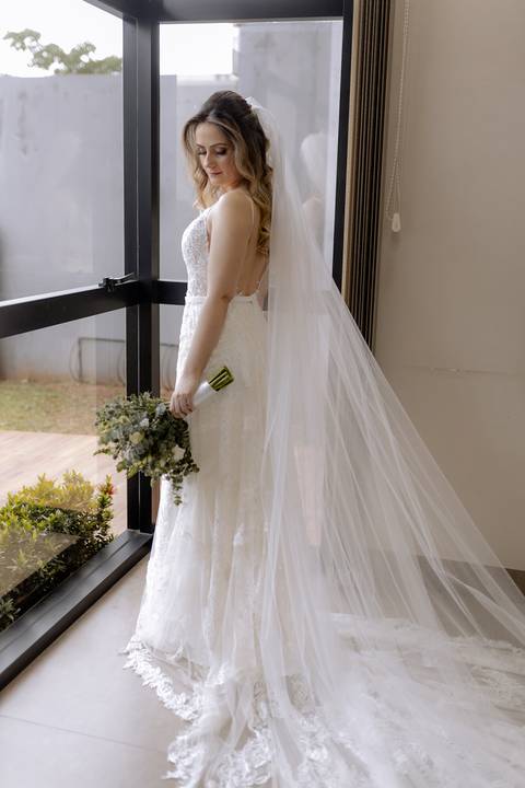 Noiva linda com seu vestido fluido com aplicações em renda'