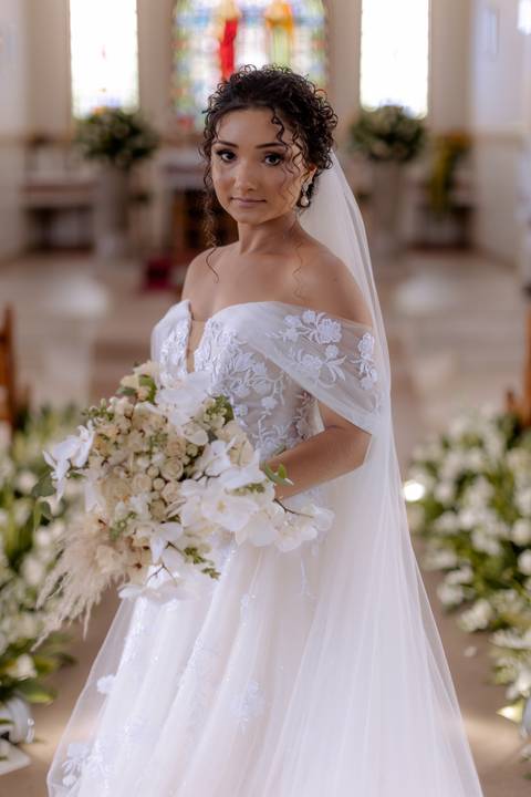 noiva segurando buquê com flores brancas'
