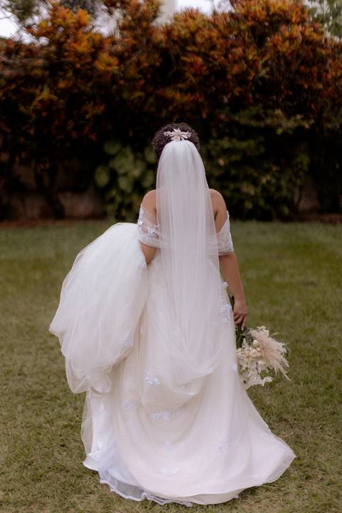 noiva segurando seu vestido e caminhando'