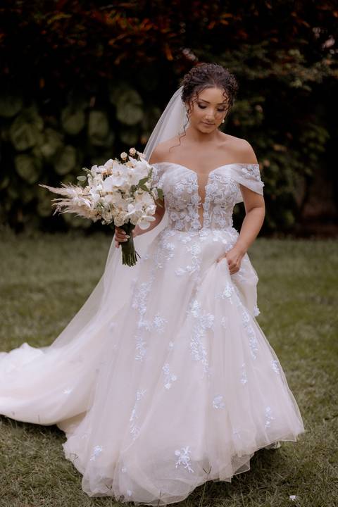 noiva segurando seu vestido e caminhando'