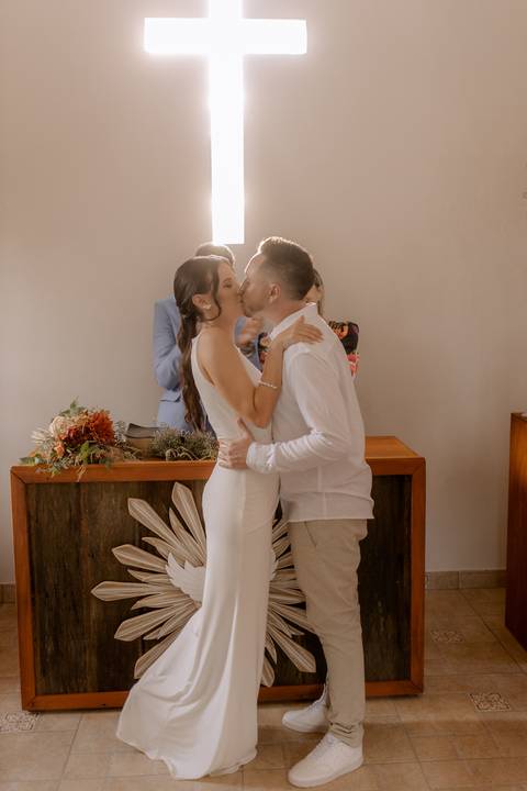 Beijo dos noivos em casamento intimista de dia'