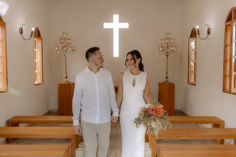 Noivos caminhando em capela'