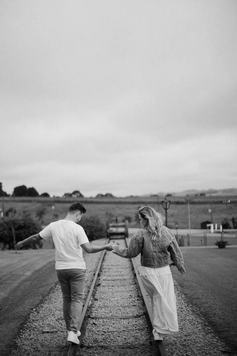 Casal andando em cima da linha de trem desativada na cidade de carambeí no paraná'