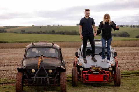Foto criativa para casal em ensaio pré wedding com carro personalizado fusca antigo com rodas para trilha'