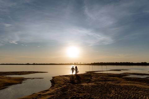 Casal apaixonado no pôr do sol em rio Paraná'
