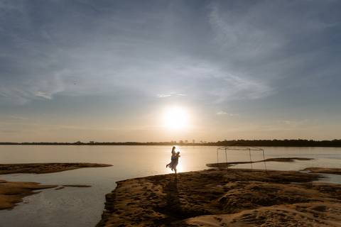 Casal apaixonado no pôr do sol em rio Paraná'