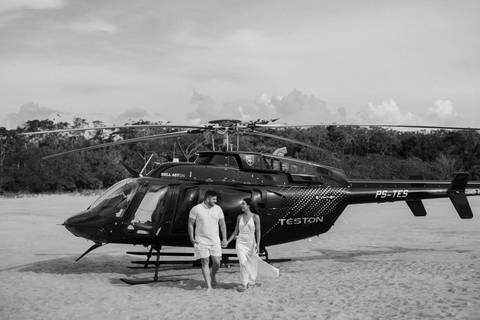 noiva e noivo andando juntos com helicóptero de fundo '