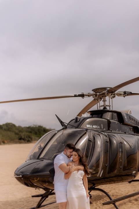 casal apaixonado em ensaio pré wedding em frente ao helicóptero '