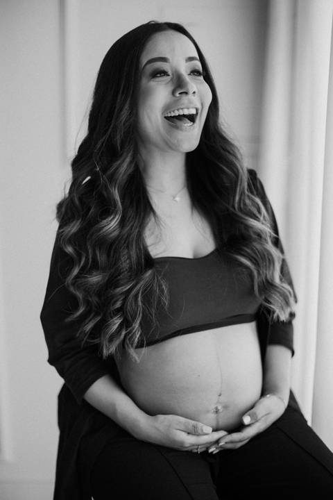 Gestante feliz em ensaio no estúdio de luz natural'