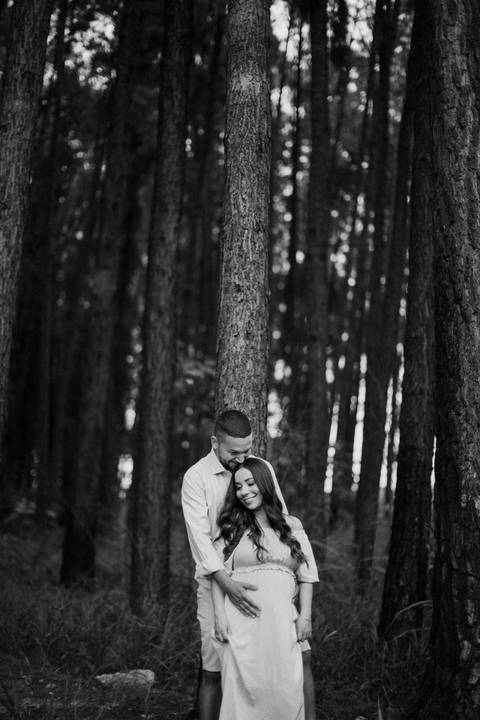 casal muito feliz no dia do ensaio de gestante na floresta'