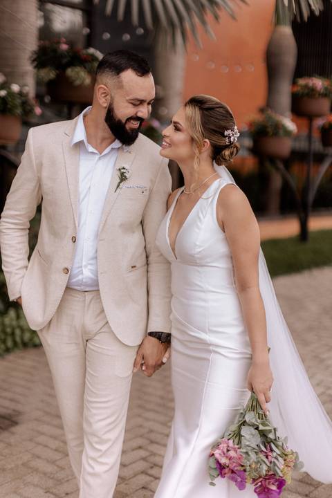 Noivo com terno bege claro e noiva com vestido minimalista para casamento de dia '