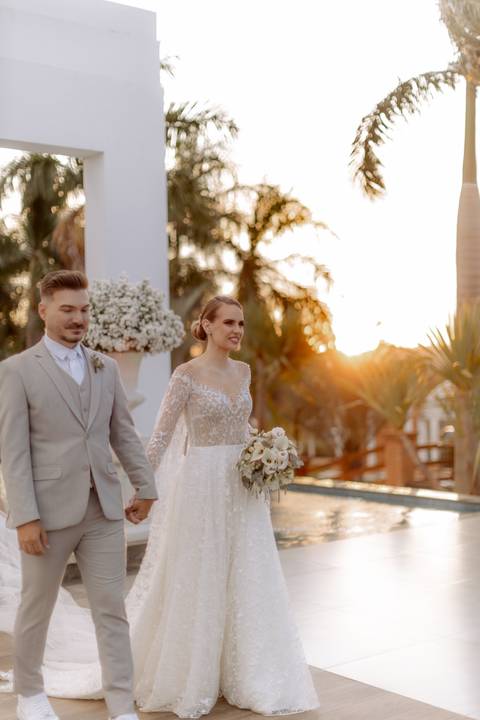saída dos noivos em casamento ao ar livre com por do sol'