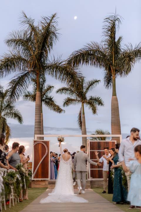 saída dos noivos em casamento ao ar livre com por do sol'
