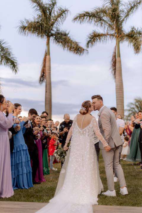 saída dos noivos em casamento ao ar livre com por do sol'