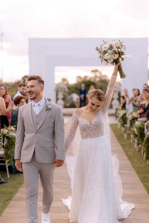saída dos noivos em casamento ao ar livre com por do sol'