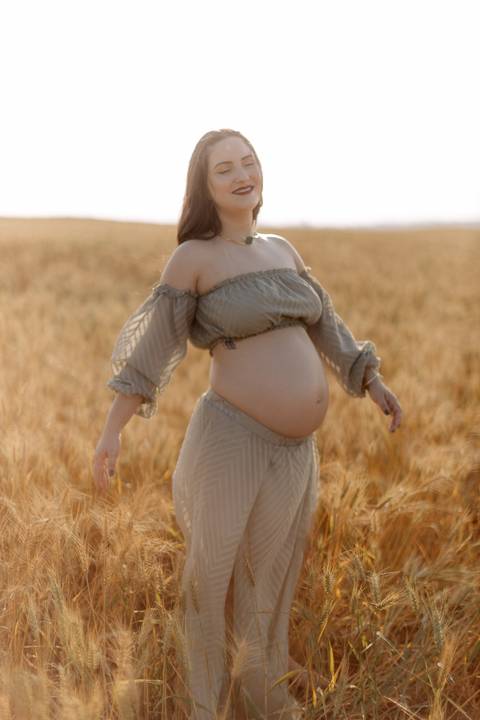 gestante linda e delicada em seu ensaio de gestante no campo '