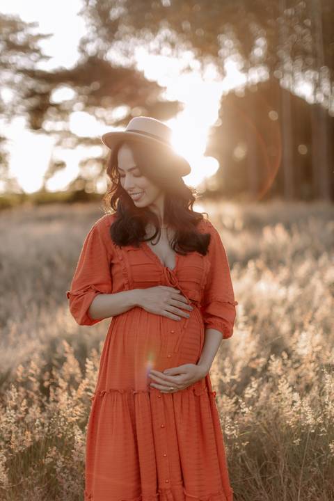 gestante linda e delicada em seu ensaio de gestante no campo '