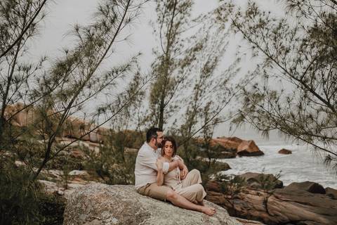 Fotos de casal sentados em uma pedra na Praia do Rosa - Sc'