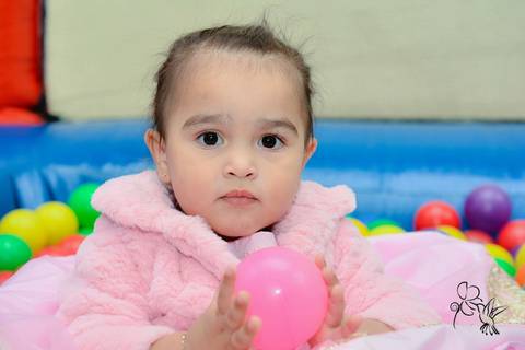 Ramona brinca na piscina de bolinha, ela está com vestido cor de rosa e sorri, by Eli Matos clicou '