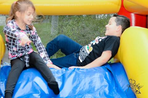 by Eli Matos clica Victor deitado no brinquedo inflável azul e amarelo'