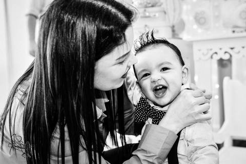 by Eli Matos, clica Mãe e filho sorriem alegremente, foto em preto e branco;.'