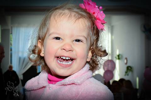 Largo sorriso da Isadora, com uma flor rosa na cabeça, clicado por  by Eli Matos'