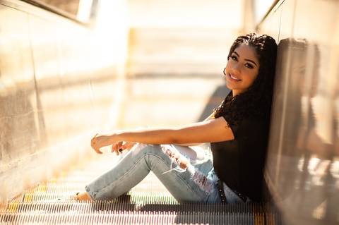 menina na  escada  rolante - sentada  - cabelo cacheado - calça  jeans clara  blusa preta  - ensaio fotografico de 15 anos  -  15 anos - 15 anos Fernanda '