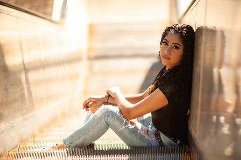 menina na  escada  rolante - sentada  - cabelo cacheado - calça  jeans clara  blusa preta  - ensaio fotografico de 15 anos  -  15 anos - 15 anos Fernanda '
