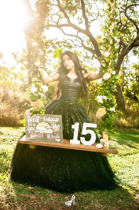 debutane  com vestido  preto  em um balanço'