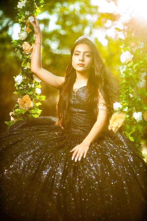 debutane  com vestido  preto  em um balanço'