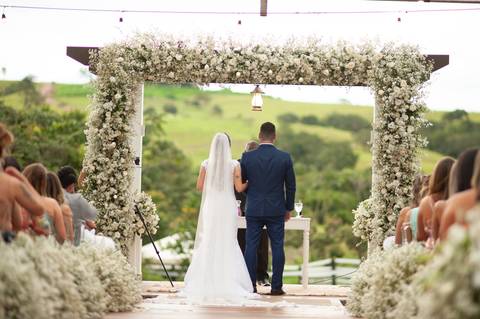 fazenda apoena  -  casamento - casamento annie e Advaldo - casamento na fazenda  - decoração nbo casamento  com os noivos e convidados  de costa '