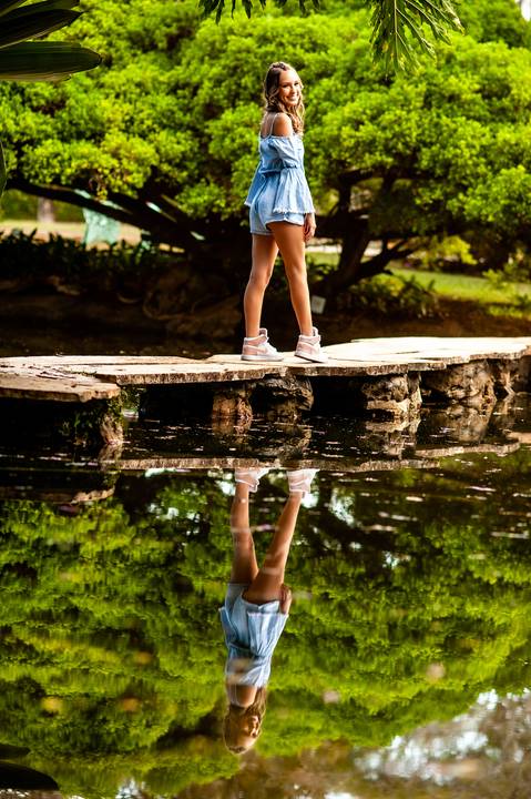 menina- 15 anos-macaquinho jeans azul- reflexo na água- lago-jardim'