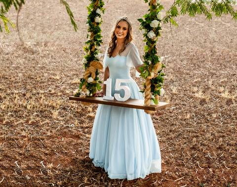 Menina-15 anos-vestido azul-balanço com flores-jardim'