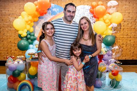 Fotografia de família em festa infantil: aniversariante Giovanna abraça a mãe ao lado do bolo no Plus Buffet em São Paulo.'