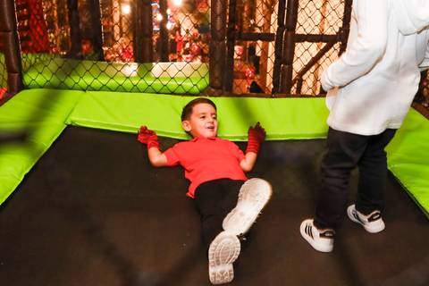 Fotografia espontânea de aniversário infantil: Henry se diverte deitado na cama elástica do Kid Recanto Buffet em São Paulo.'