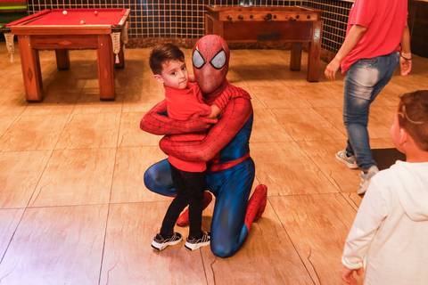 Fotografia de aniversário registra momento especial em que o aniversariante Henry abraça o personagem do Homem-Aranha no Kid Recanto Buffet.'