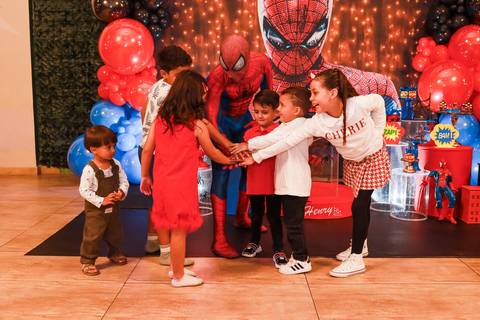 Fotografia espontânea de aniversário: Homem-Aranha e as crianças fazem um gesto de união durante a festa do Henry no Kid Recanto Buffet.