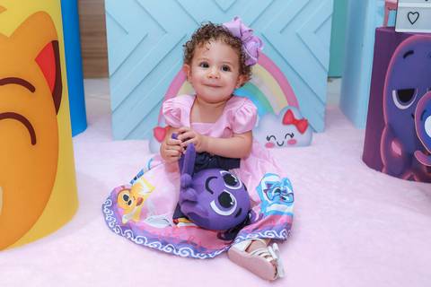 Aniversariante sorrindo na sua festa infantil em Guarulhos, segurando um boneco do tema Bolofofos.'