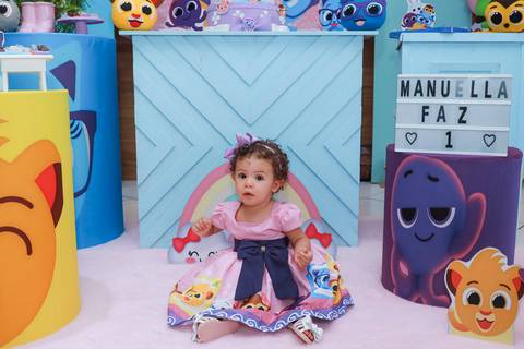 Aniversariante Manuella na decoração da sua festa de 1 ano em Guarulhos, com letreiro e tema Bolofofos.'