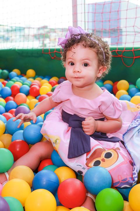 Aniversariante se divertindo na piscina de bolinhas durante sua festa infantil em Guarulhos, foto espontânea.'