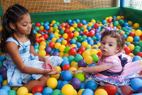 Aniversariante e amiga interagindo na piscina de bolinhas, momento registrado por fotógrafo de festa infantil em Guarulhos.'