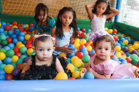 Crianças brincando juntas na piscina de bolinhas em aniversário infantil fotografado em Guarulhos.'