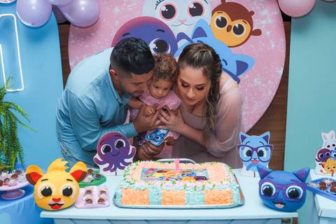 Família reunida na hora do parabéns em aniversário de 1 ano em Guarulhos, foto do bolo com tema Bolofofos.'